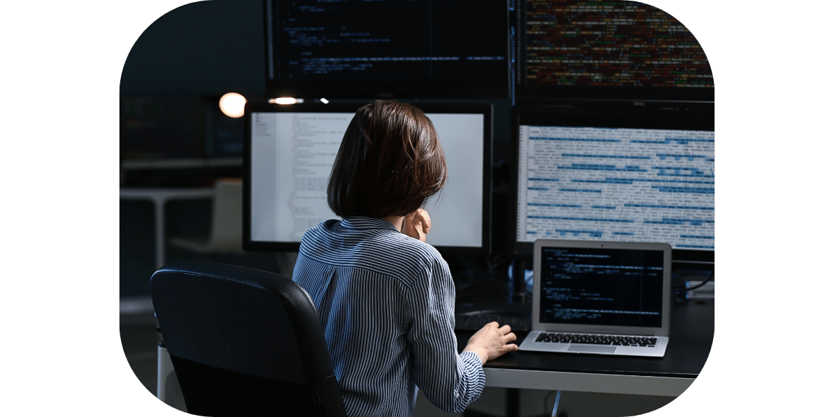 Lady inspecting 3 computer screens