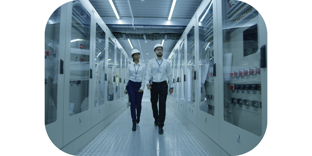 Workers walking in the control room of an electrical plant. 