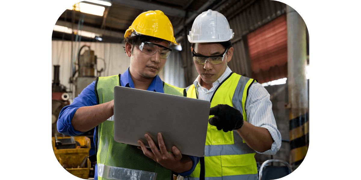 Two workers viewing information on a mobile computer in an energy plant. 